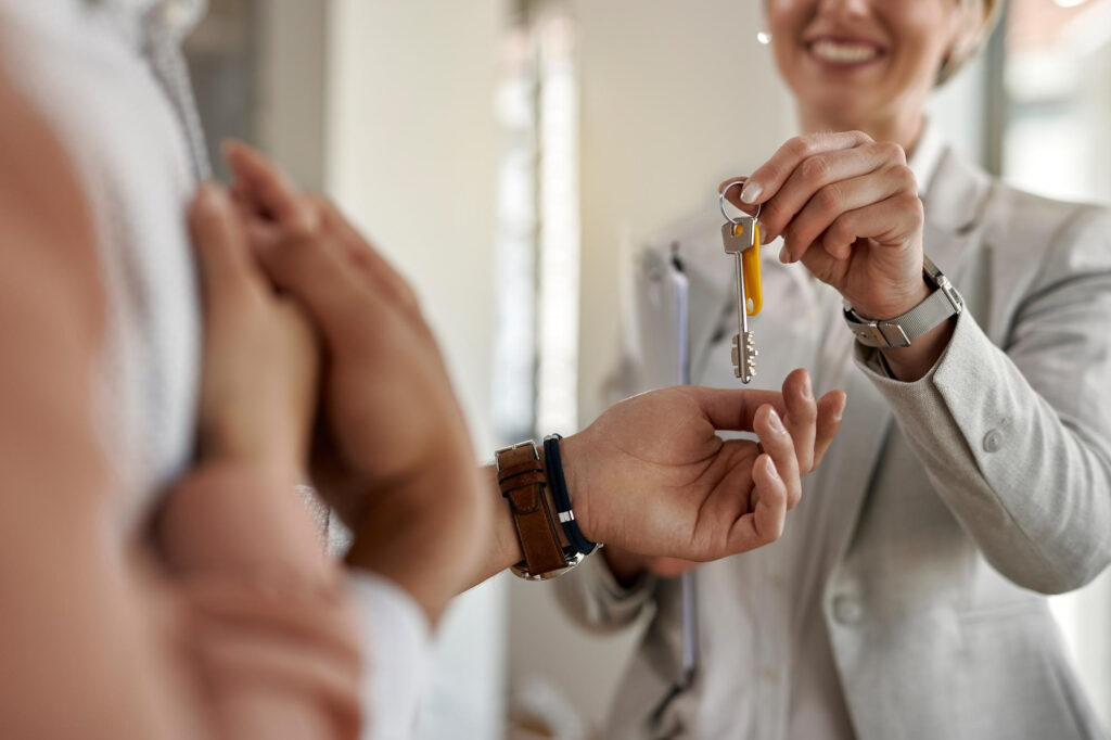 Une agente immobilière remet les clés lors de la revente d’un bien en LMNP.