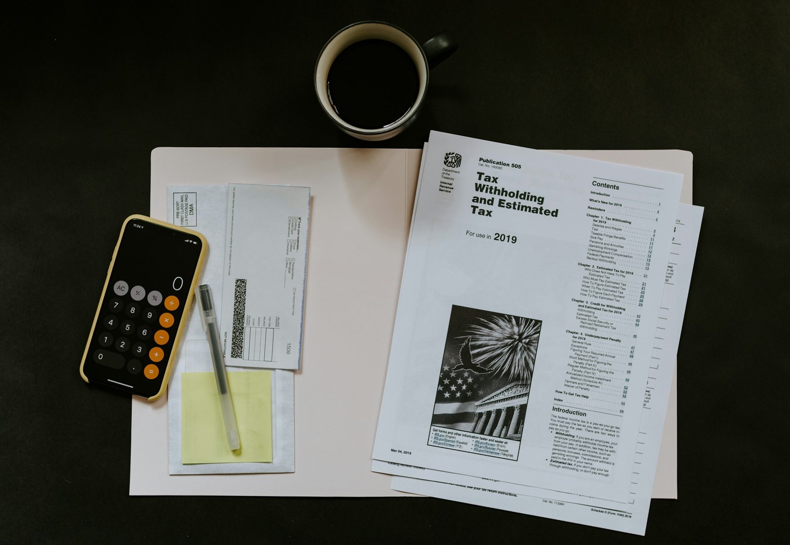 Une tasse de café, une calculatrice et des formulaires fiscaux pour se déclarer en LMNP.