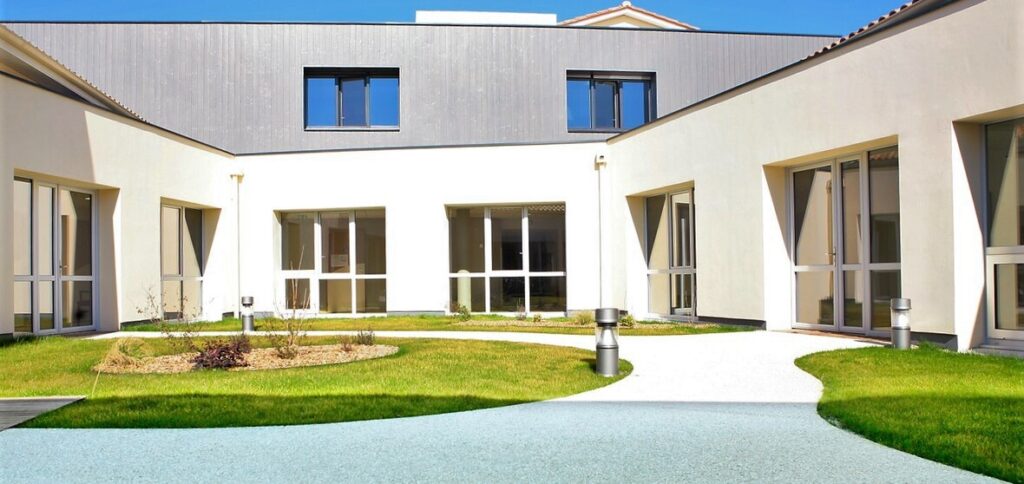 Façade principale de la Résidence du Tertre entourée de verdure à Fronsac