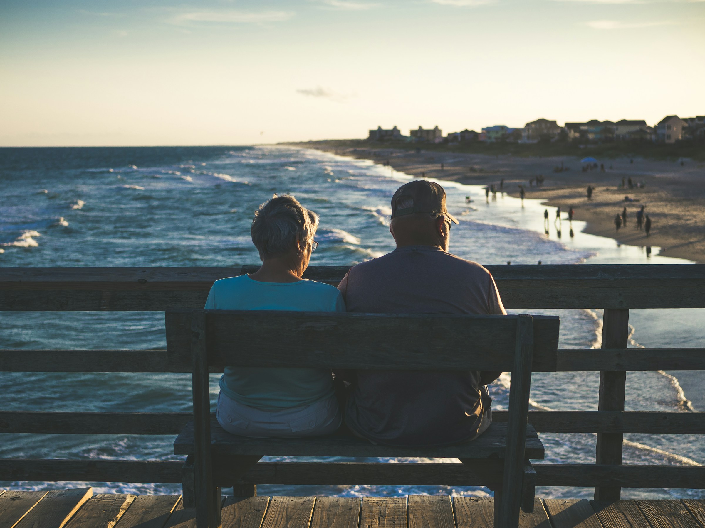 Couple de retraités observant la mer depuis un banc, symbolisant les objectifs de revenus passifs via un placement en EHPAD et LMNP.