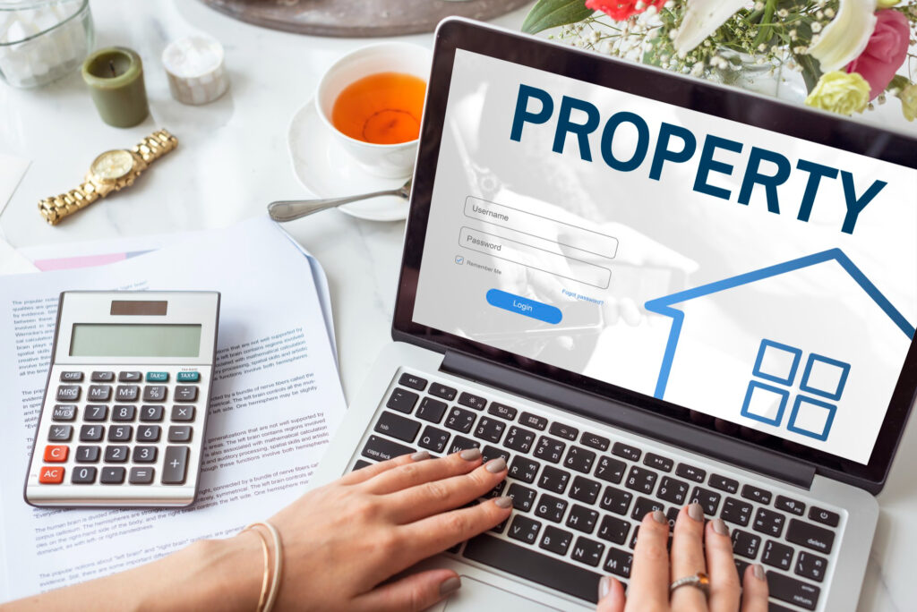 écran d’ordinateur affichant une interface immobilière avec documents et calculatrice, illustrant la gestion du déficit foncier LMNP
