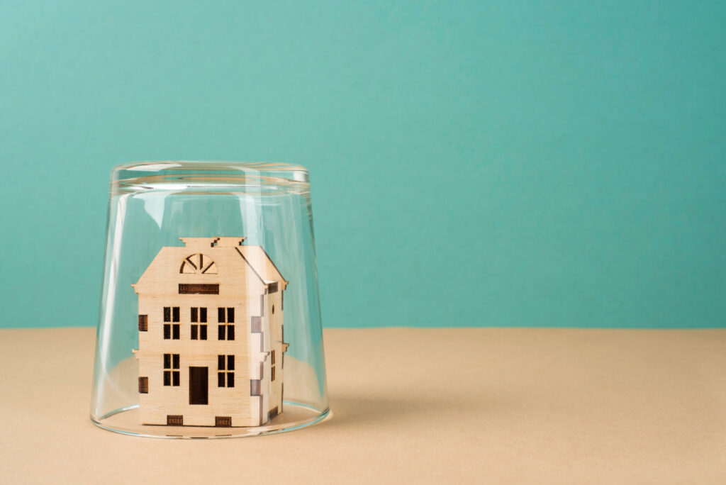 Maison sous cloche symbolisant la protection fiscale offerte par le déficit foncier LMNP