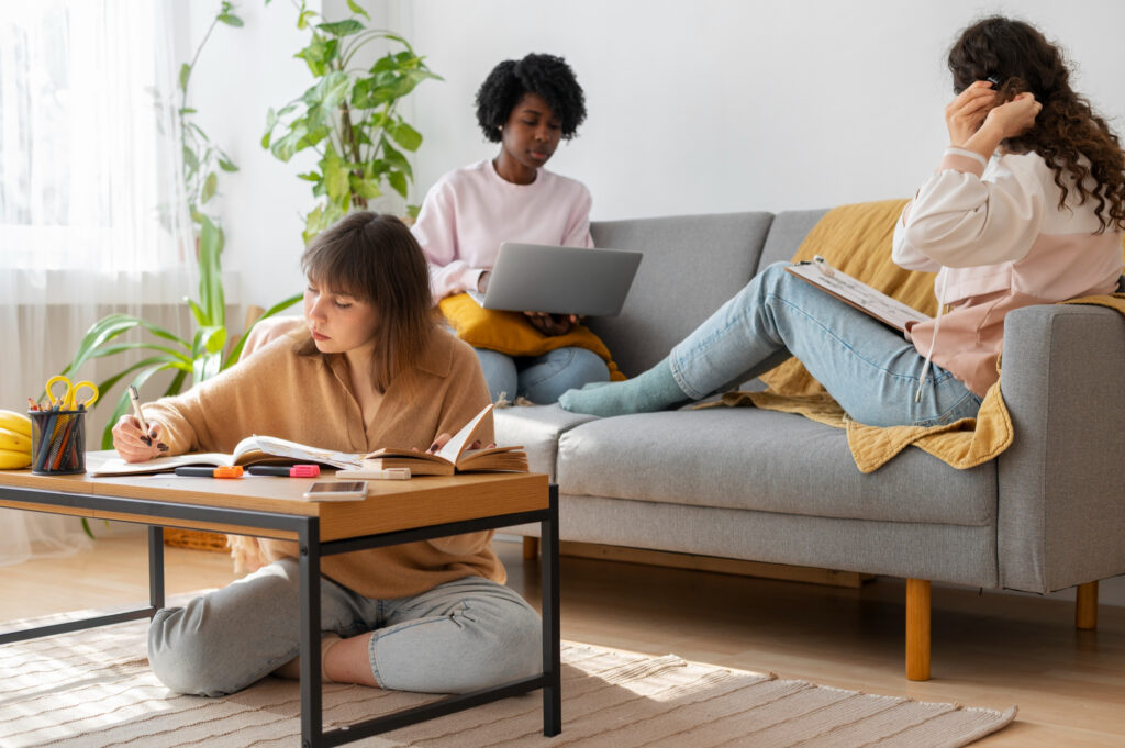 Jeunes locataires étudiant et travaillant dans un salon lumineux, typique d’un bien destiné à une simulation LMNP en colocation.