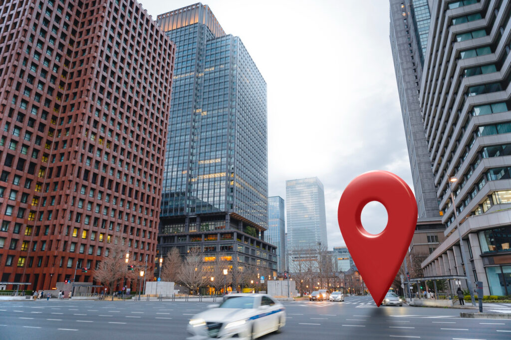 Vue urbaine avec repère de géolocalisation géant – signalement d’un actif immobilier exploité en LMNP à l’IS.