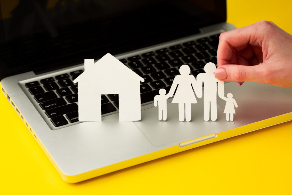 assurance loyers impayés LMNP illustrée par une maison et une famille en papier sur un ordinateur