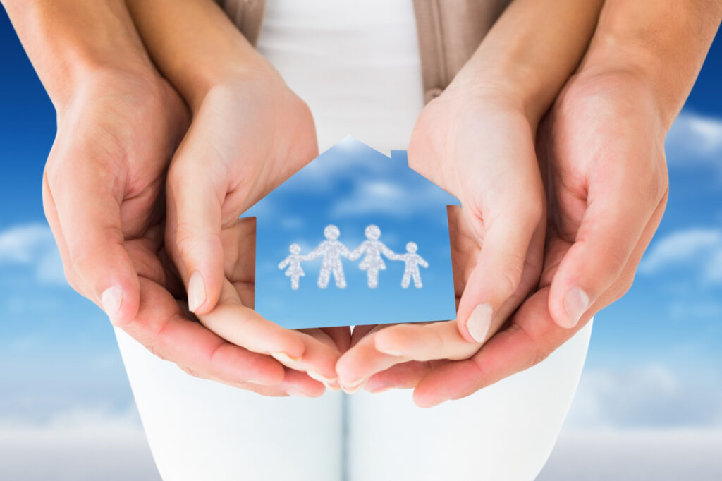 assurance loyers impayés LMNP représentée par une maison et une famille protégées dans des mains ouvertes